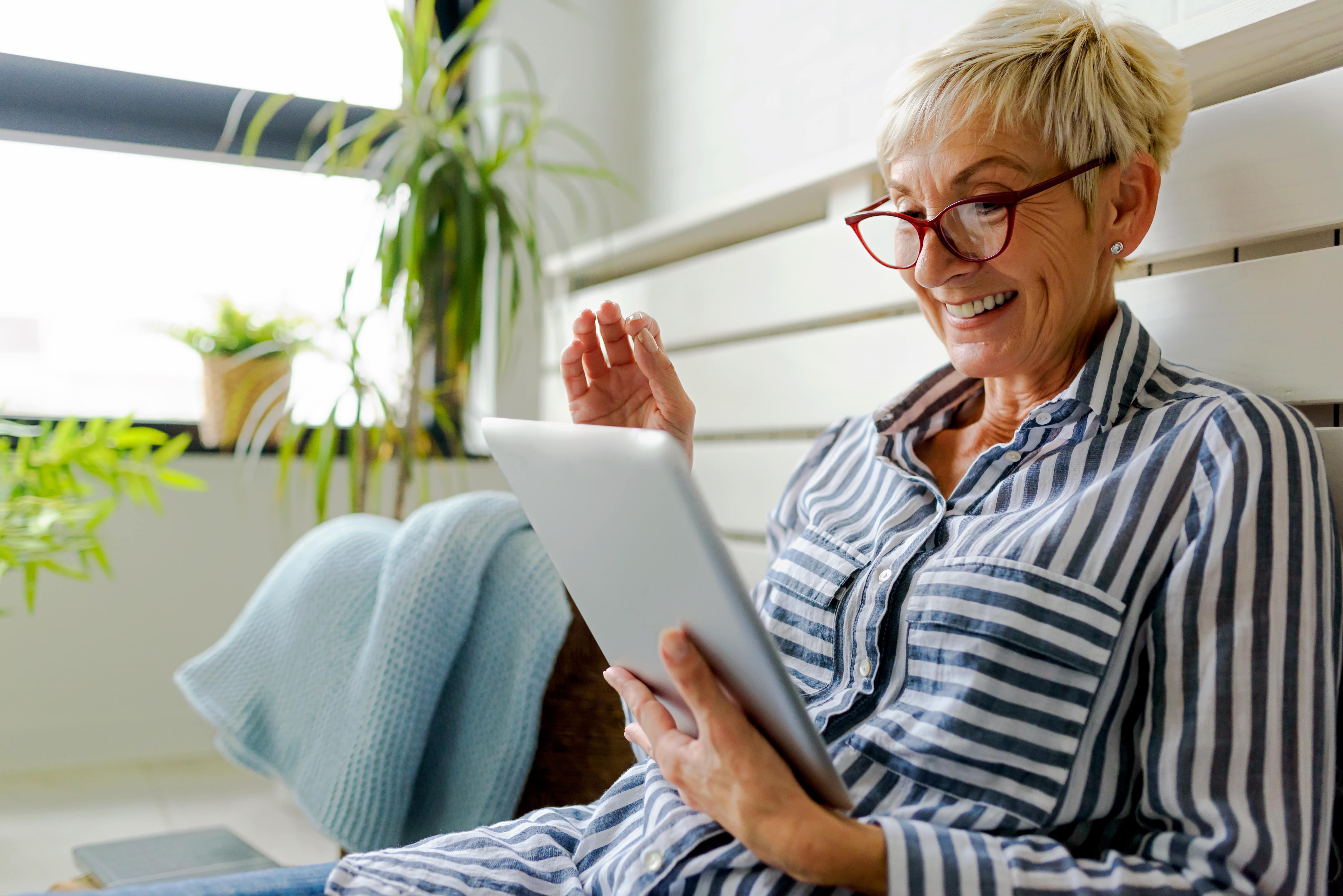  Woman holding and smiling at a tablet